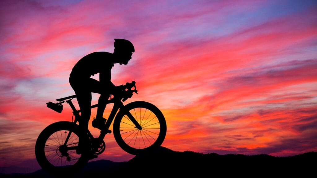 rowerzysta na tle nieba, zachodu słońca.