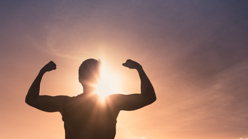 Silna wolna, mężczyzna w geście zwycięstwa podnosi ręce.